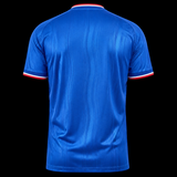 Kitted Up Manchester United 2026/2027 kids away jersey in blue with red and white striped trim, back view.