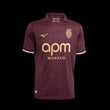 Kitted Up Monaco 2026/2027 away football jersey in dark burgundy with gold accents and a subtle geometric pattern.