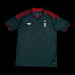 Kitted Up Nottingham Forest 2026/2027 kids away jersey in dark green with red accents and white logo details.
